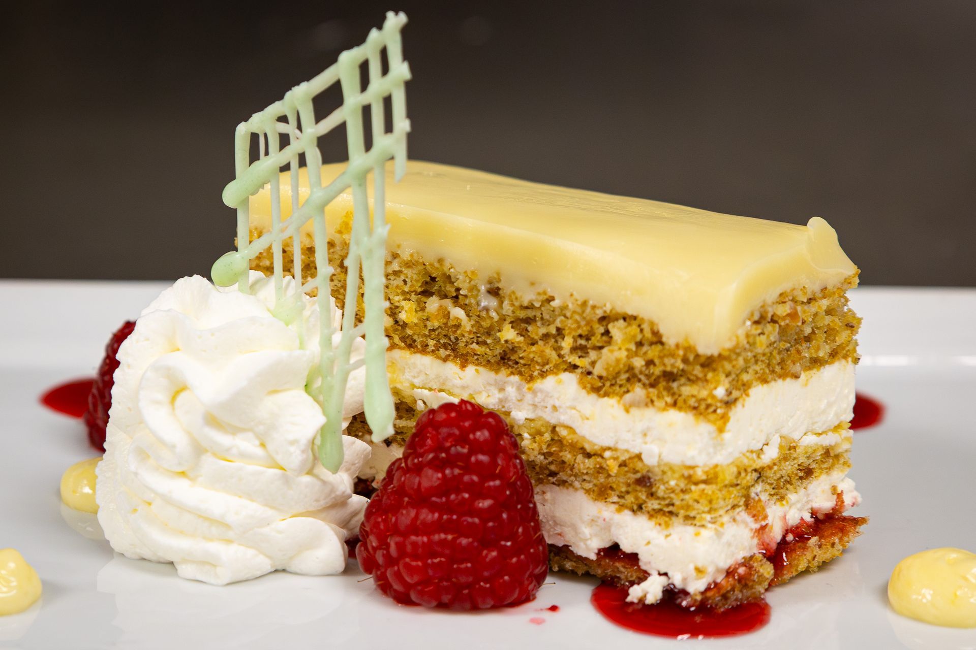 Pistachio opera cake served with lemon champagne sabayon sauce