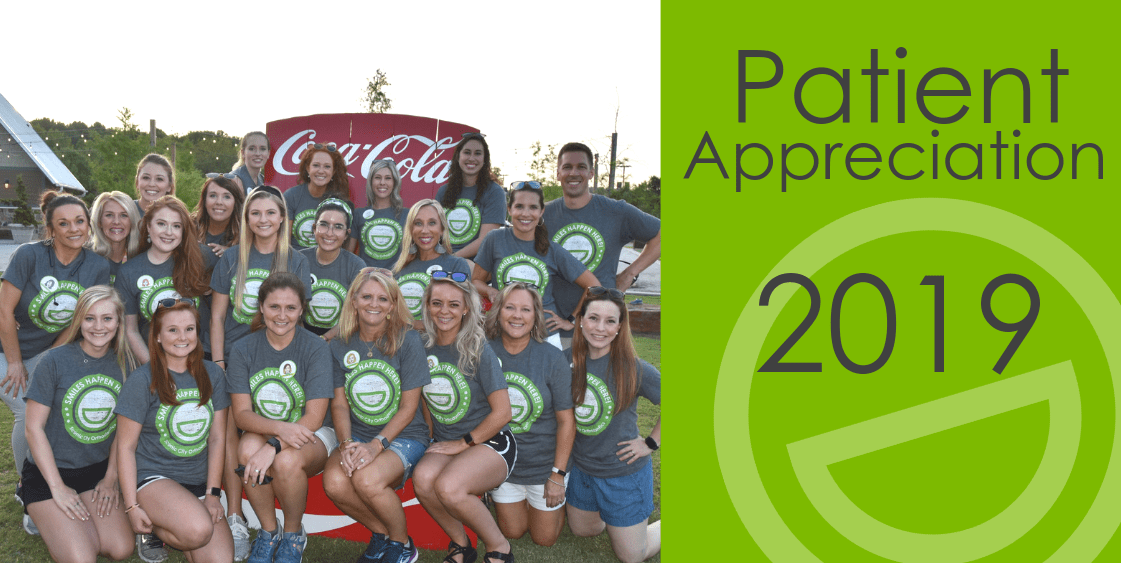 A group of people are posing for a picture in front of a coca cola truck.