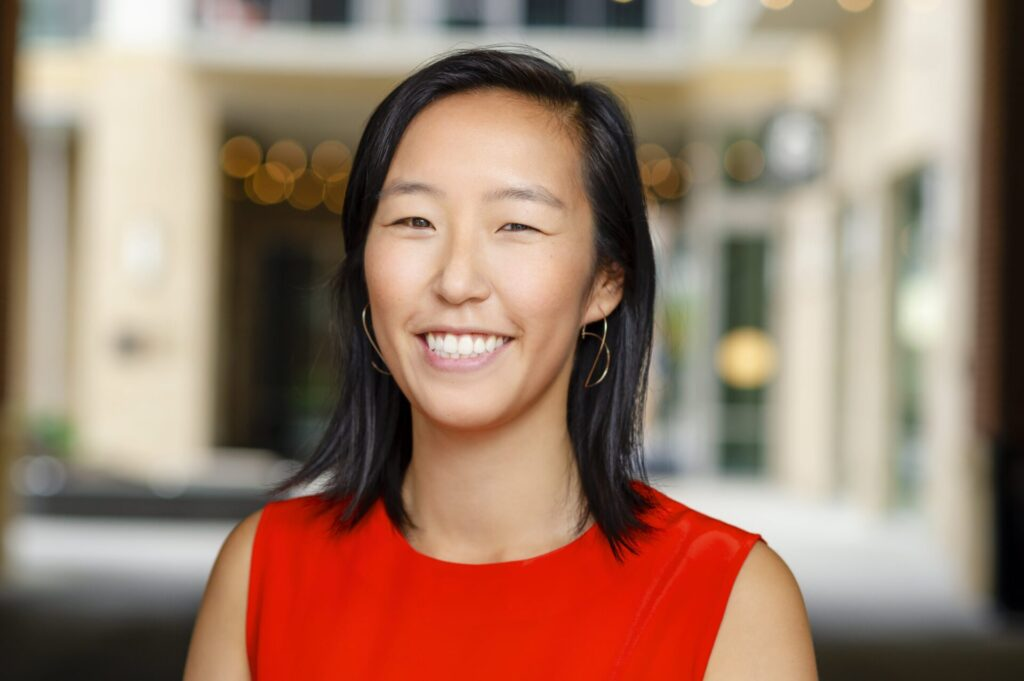 A woman in a red dress is smiling for the camera.