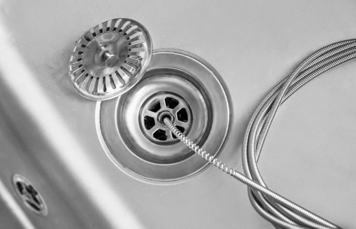 plumber unclogging shower drain