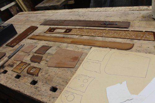 pezzi di legno da restaurare appoggiati su una superficie da lavoro