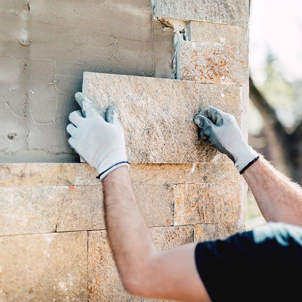Worker Installing Stone On New Building — Waynesville, NC — Stoneworld of NC, LLC
