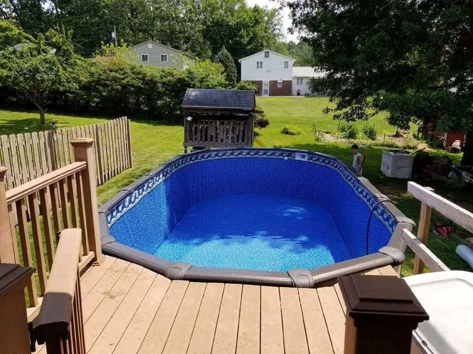 A swimming pool is sitting on top of a wooden deck