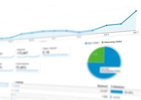 Blurred analytics dashboard with rising blue line chart and blue-green pie chart