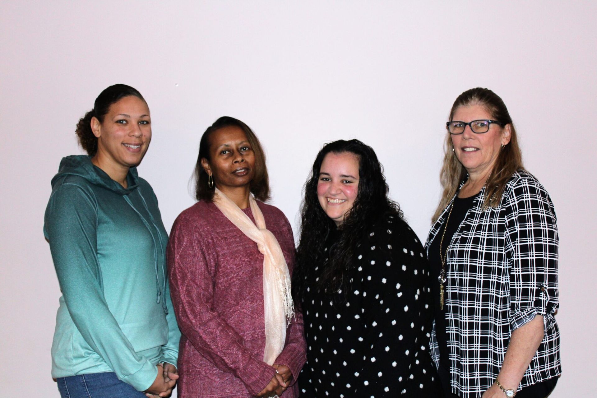 A group of four women are posing for a picture together.
