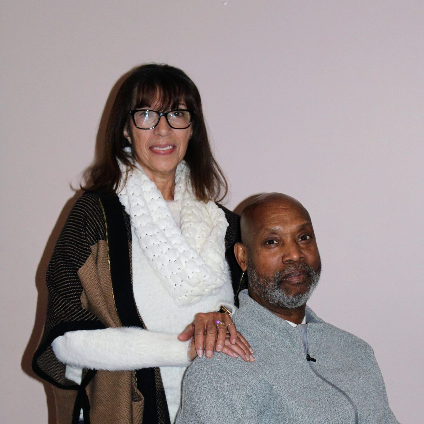 A woman standing next to a man in a wheelchair
