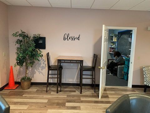 A room with a table and chairs and a sign on the wall that says blessed.
