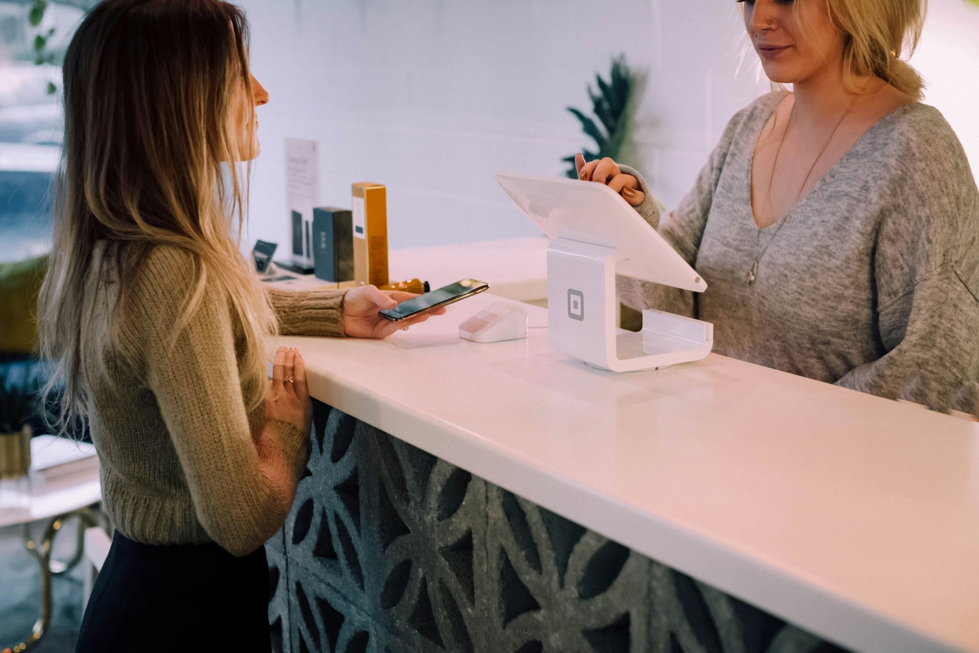 A woman is paying for something with a credit card at a counter.