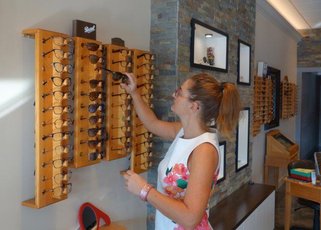 Glasses Frames — Woman Choosing Eyewear Frames in Belleair Bluffs, FL