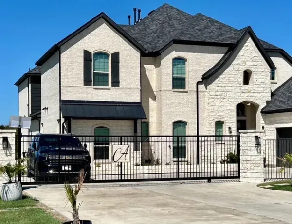 A large white house with a black truck parked in front of it