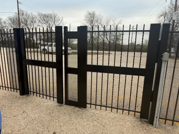 A black fence with a gate in the middle of it