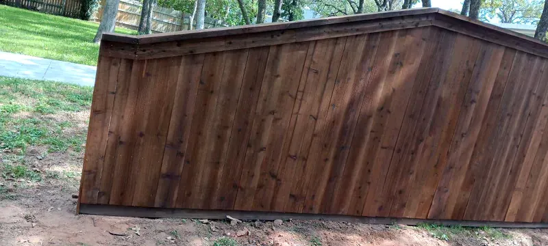 A wooden fence is sitting in the middle of a grassy field.