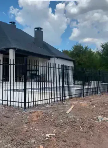 A white house with a black fence around it.