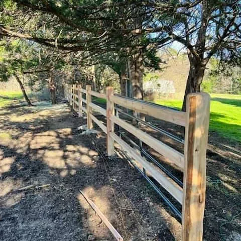 A wooden fence is being built in the middle of a forest.