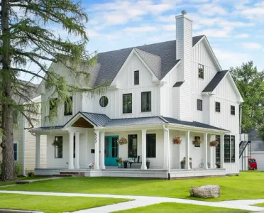 A large white house with a blue door and porch.