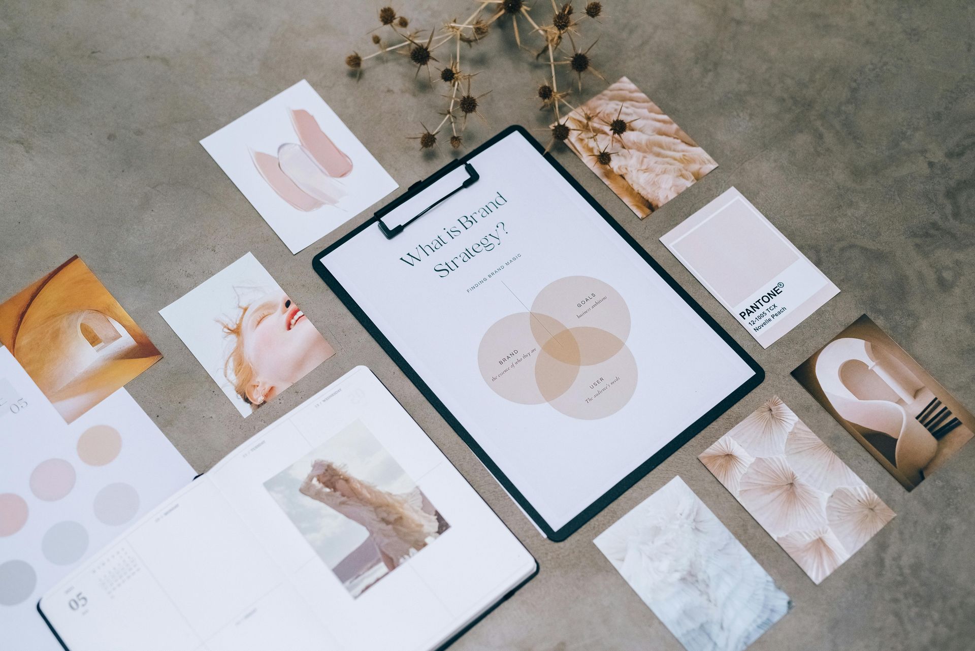 A clipboard is sitting on top of a table surrounded by papers and pictures.