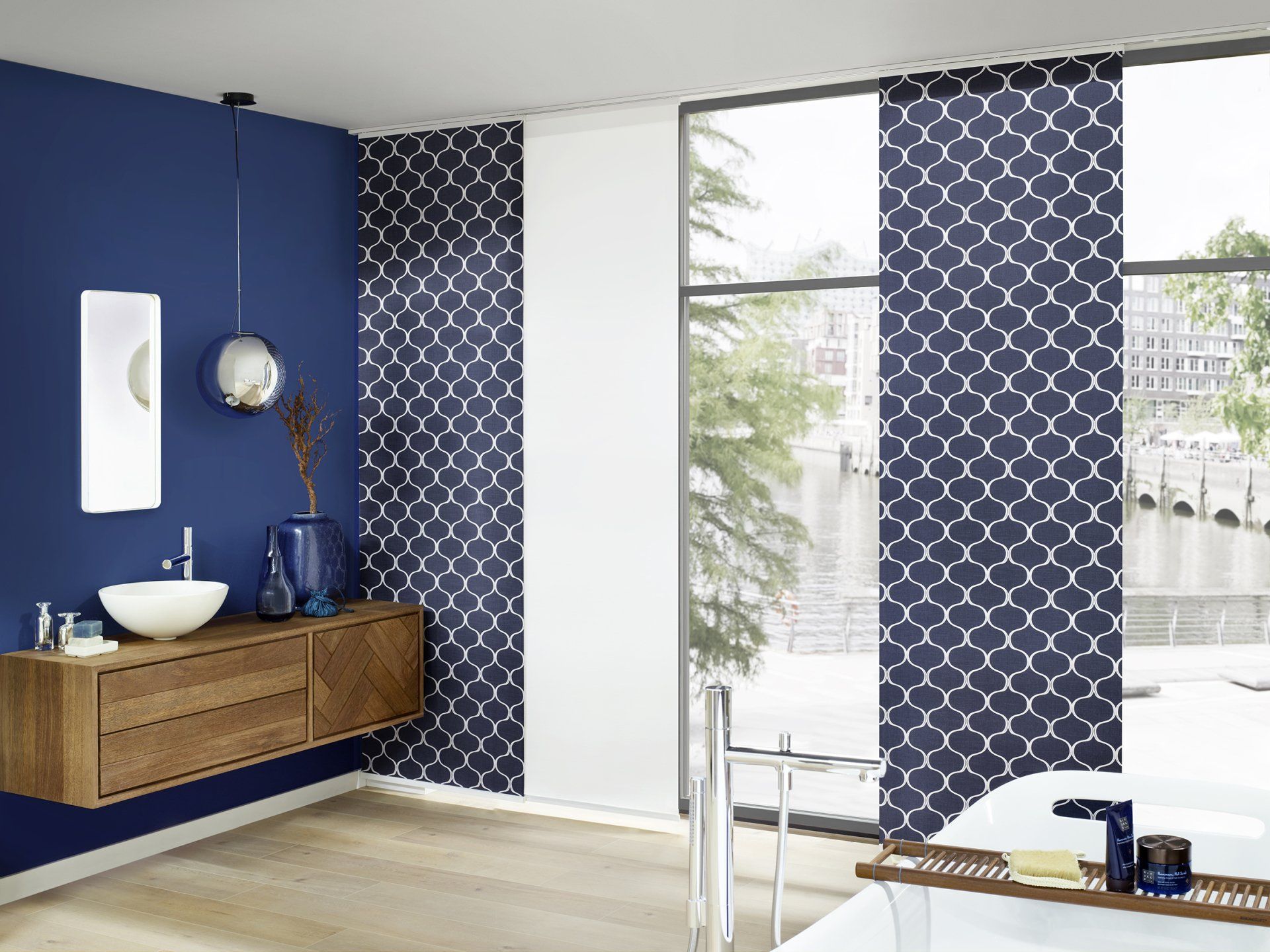 Badezimmer mit dunkelblauer Wand mit Mustervorhängen in dunkelblau und weiß