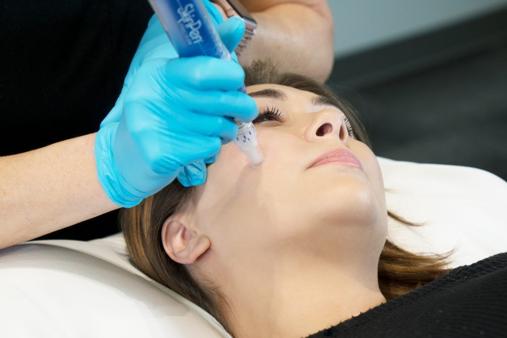 A woman is getting a treatment on her face.