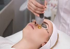 A woman is getting a laser treatment on her face.