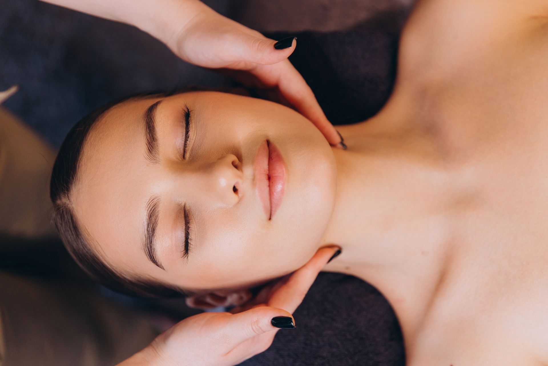A woman is getting a massage on her face in a spa.