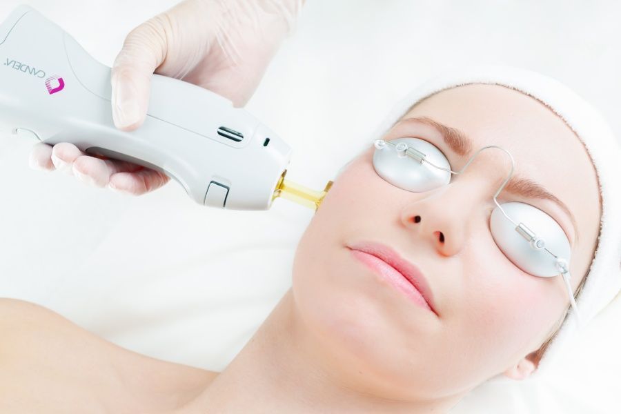 A woman is getting a laser treatment on her face.