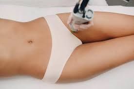 A woman is getting a laser hair removal treatment on her legs.