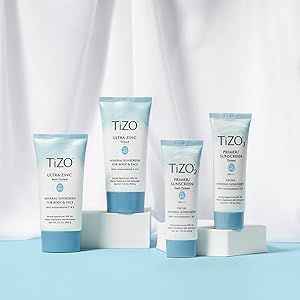 A group of tubes of tizo sunscreen are sitting on top of each other on a table.