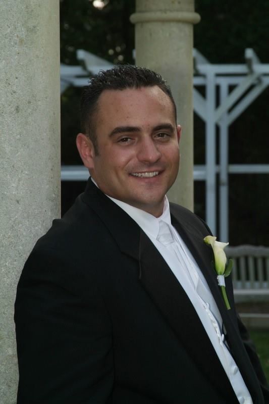 A man in a tuxedo with a white flower on his lapel
