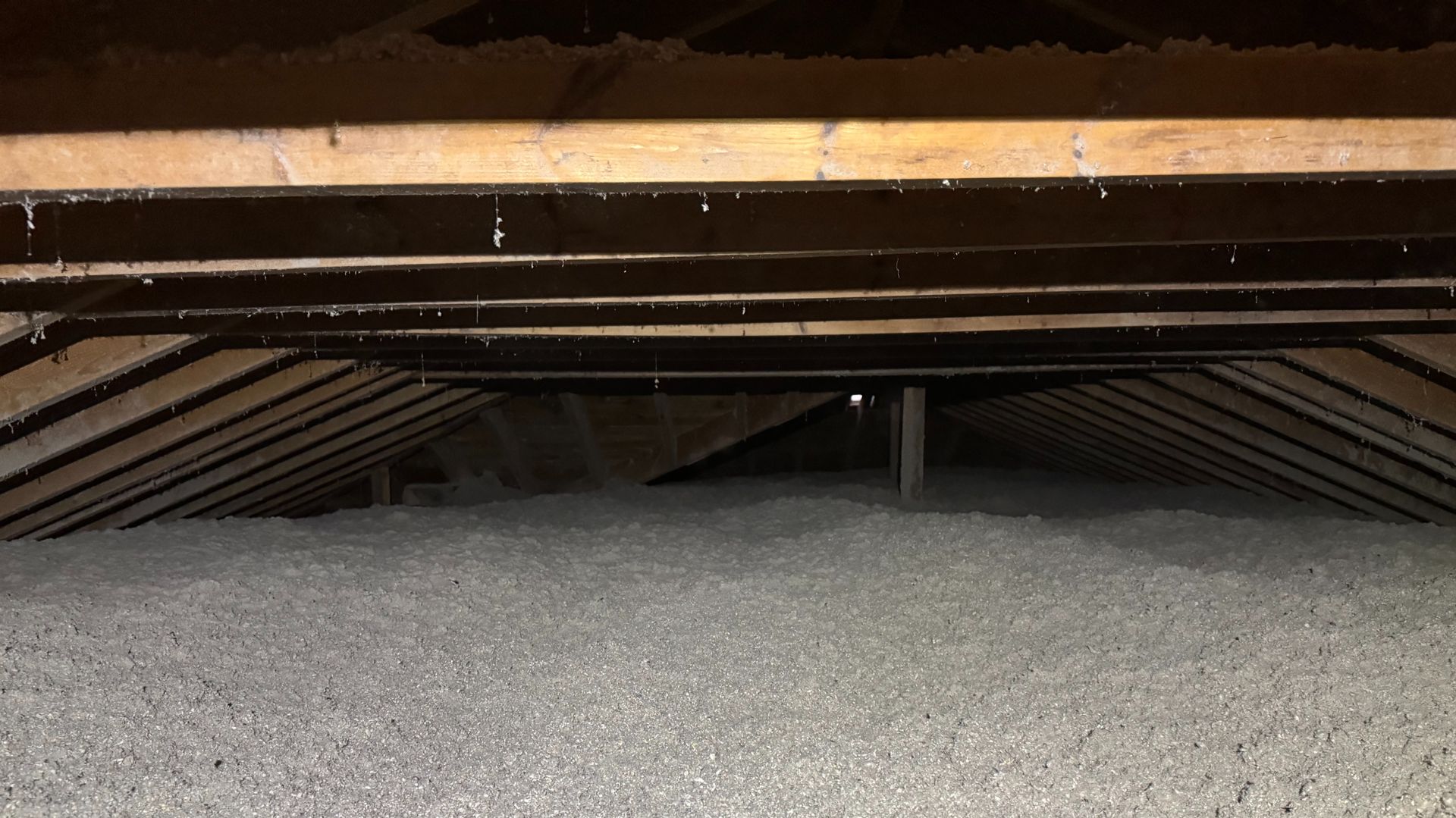 Hand spraying foam insulation into walls