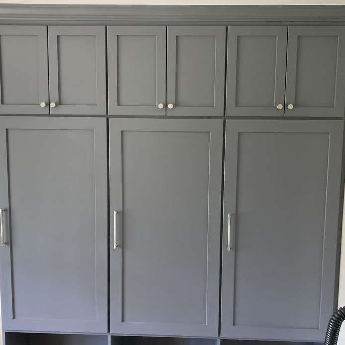 Gray built-in cabinets with silver handles and white knobs, mounted on a wall.