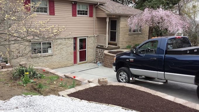 A blue truck is parked in front of a house.