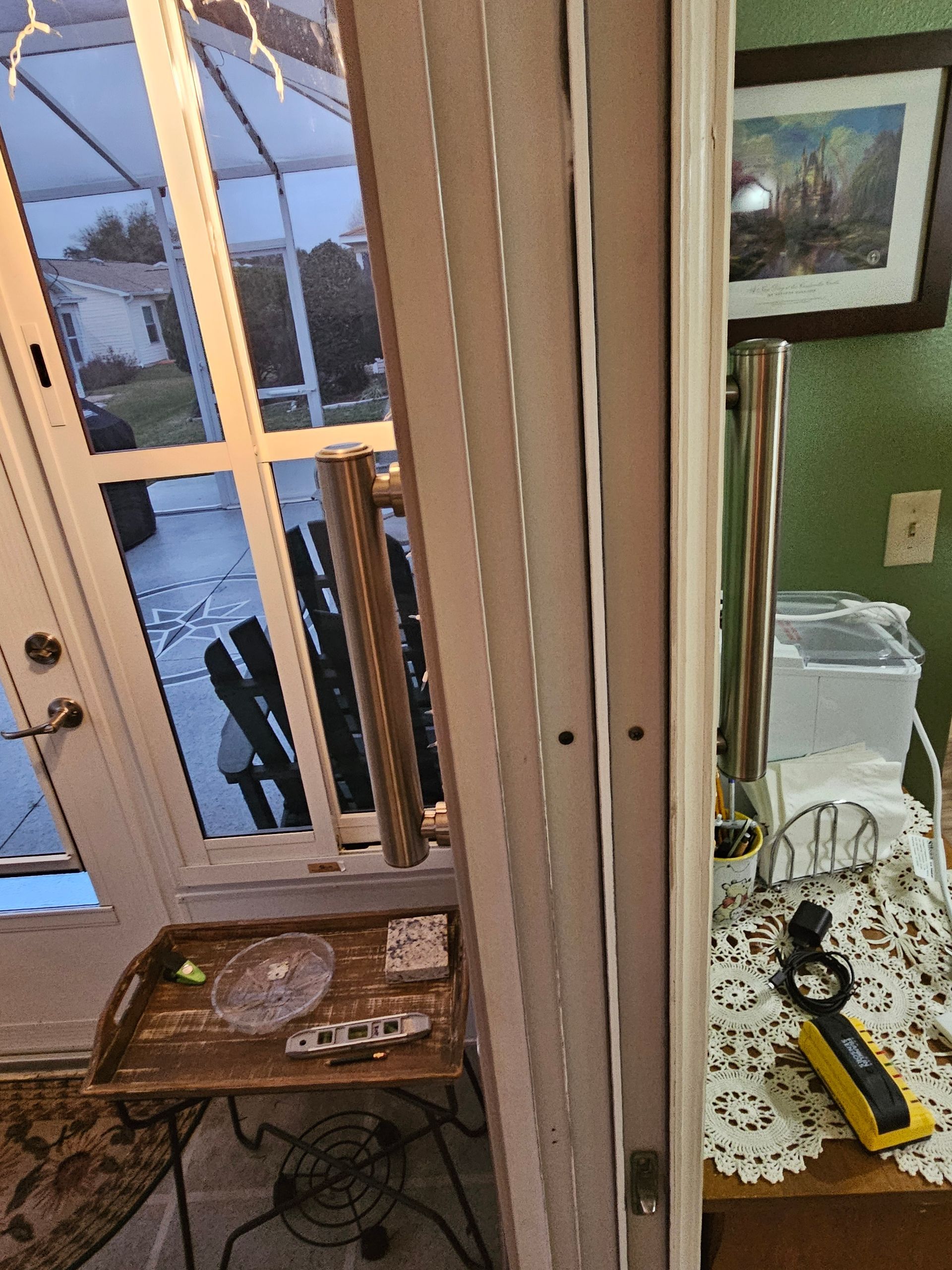 Vertical blinds beside a white door, partial view of a table, and outdoor view.