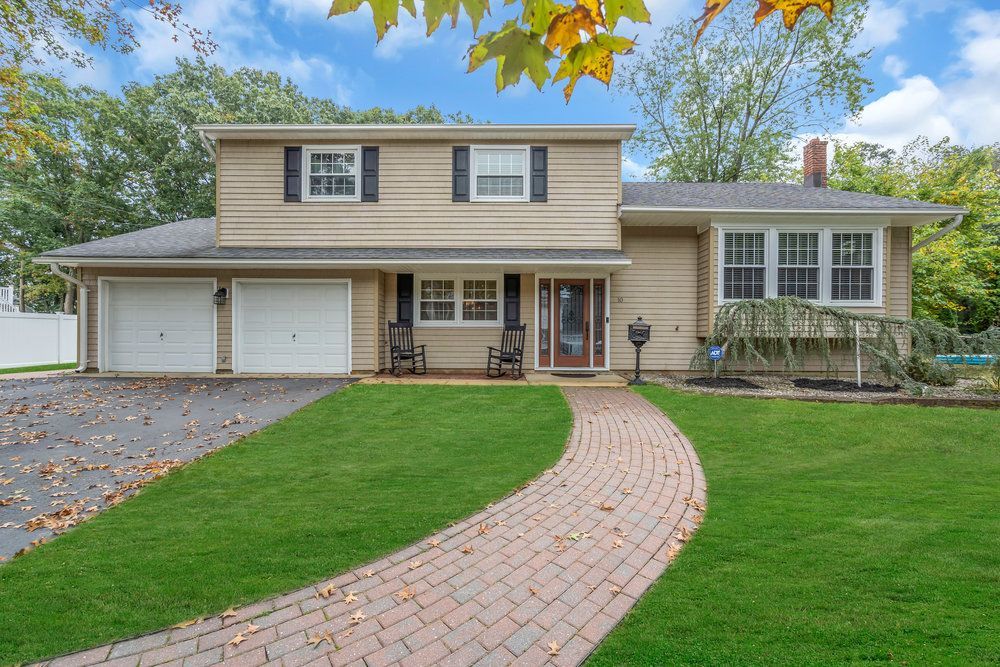 A large house with a brick walkway leading to it.
