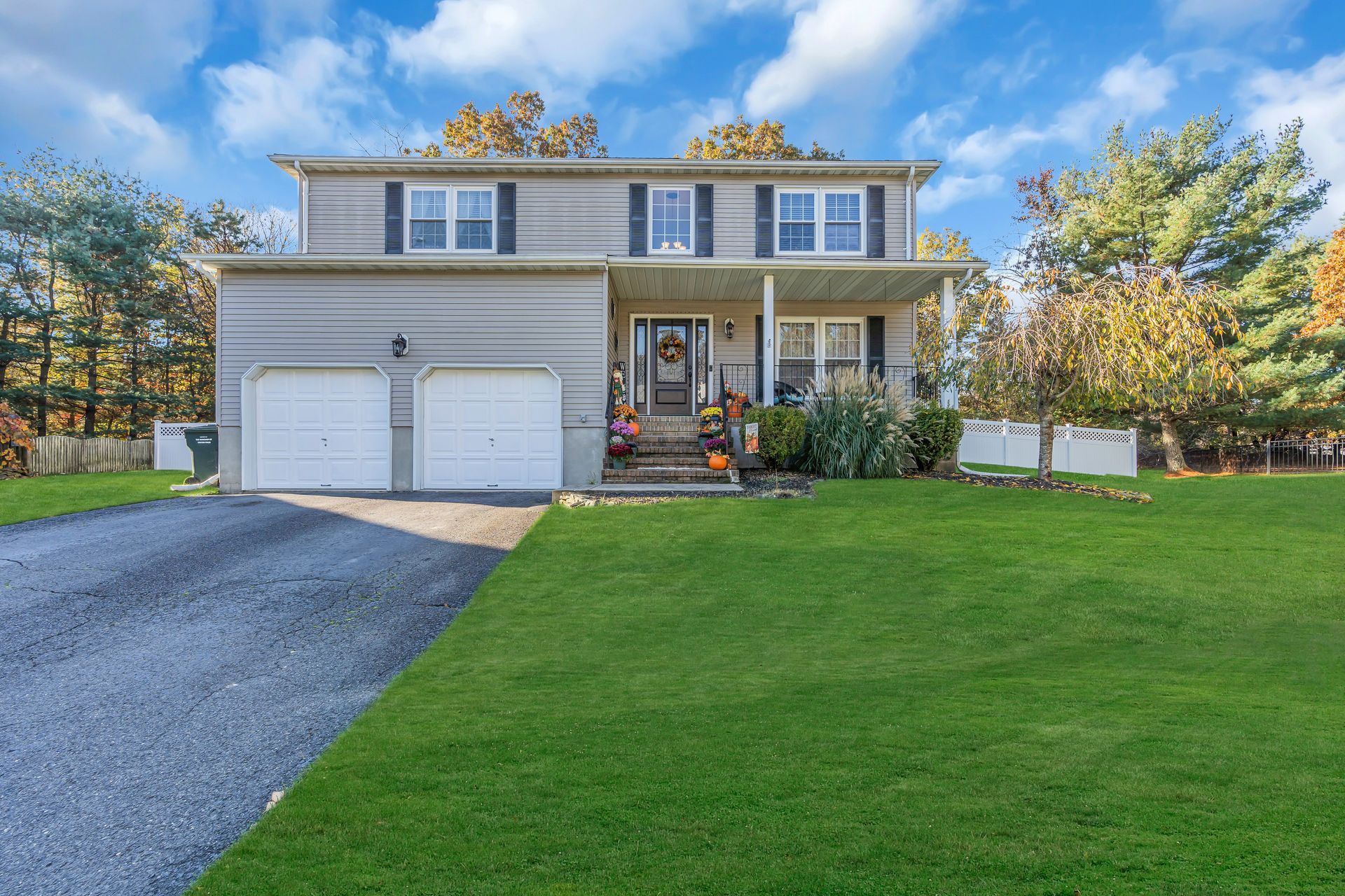 A large house with two garages and a large lawn in front of it.