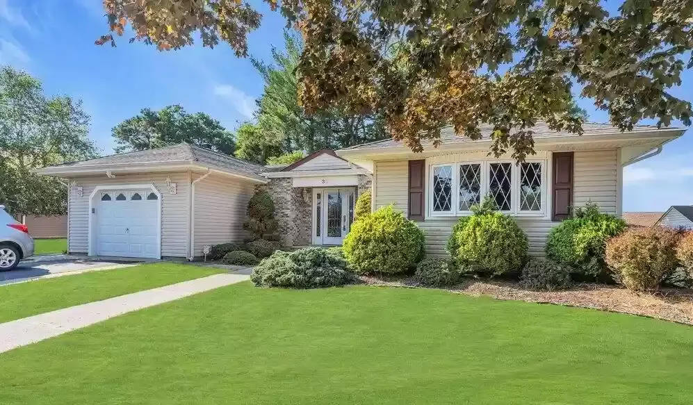 A house with a car parked in front of it.