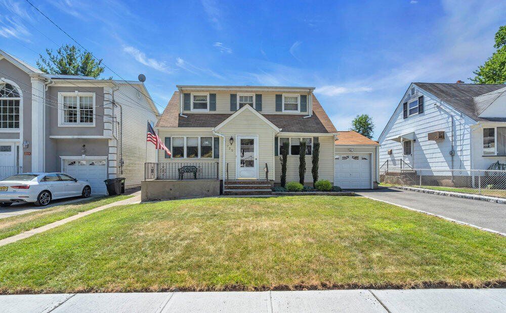 A house with a large lawn and a car parked in front of it.