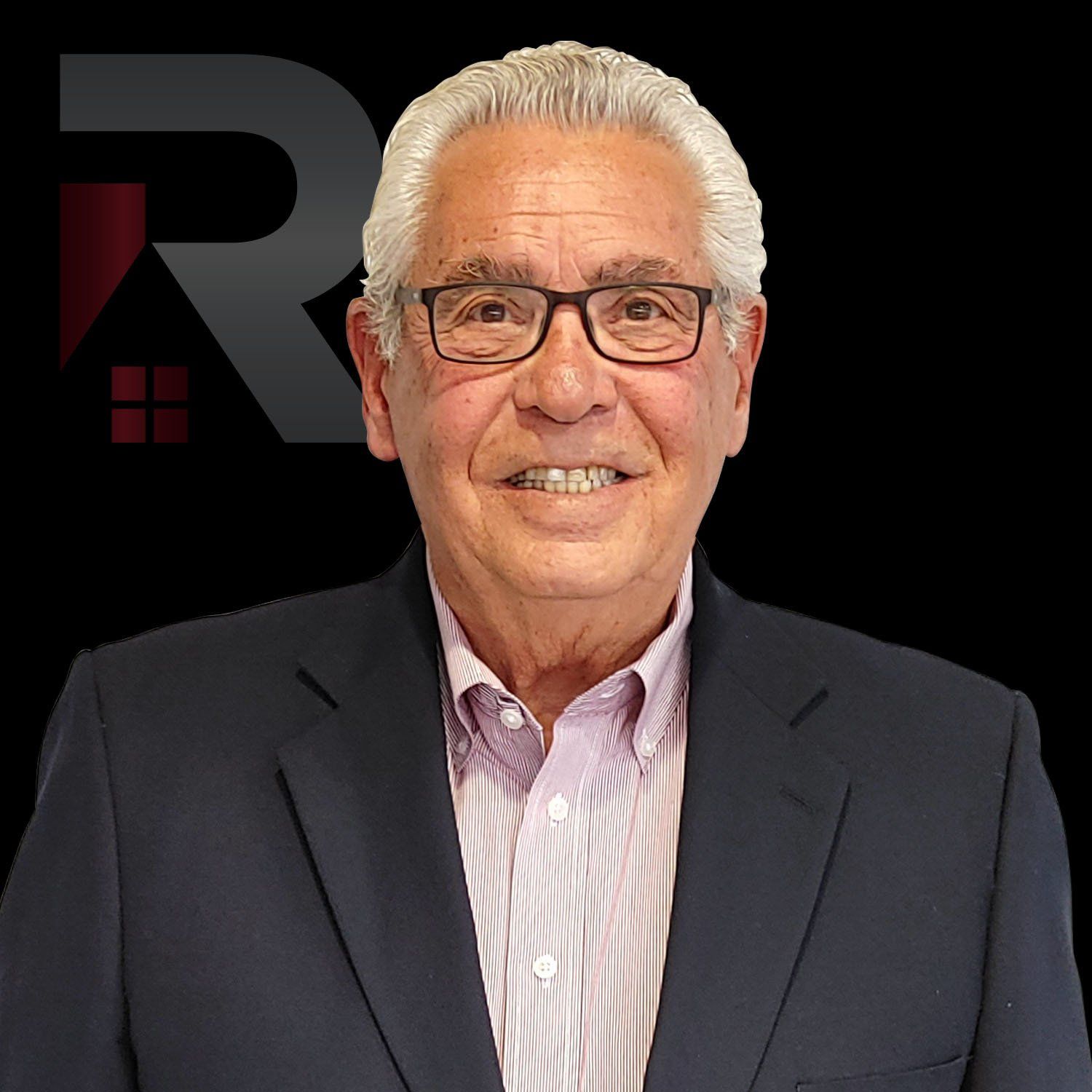 John Fatigati in a suit and glasses is smiling for the camera.