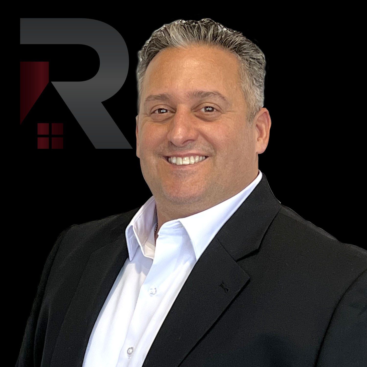 A man in a suit and white shirt is smiling for the camera.