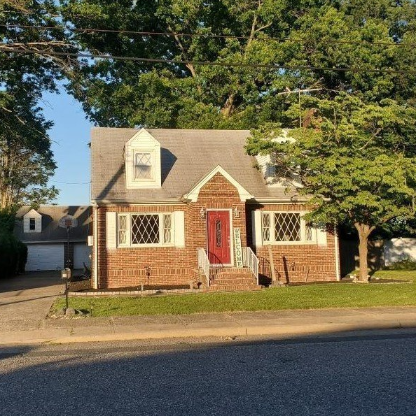 A brick house with a red door and white shutters