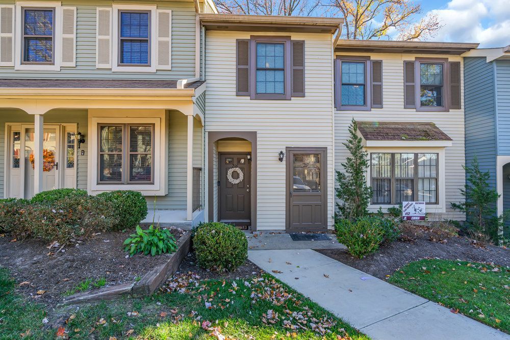 The front of a house with a porch and a walkway leading to it.