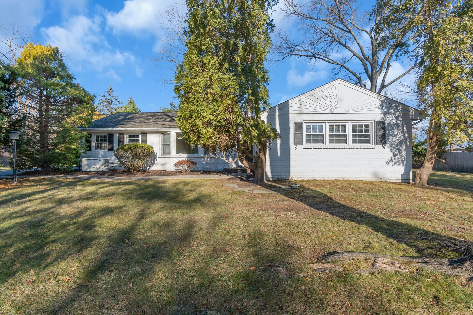 A white house with a large lawn in front of it.