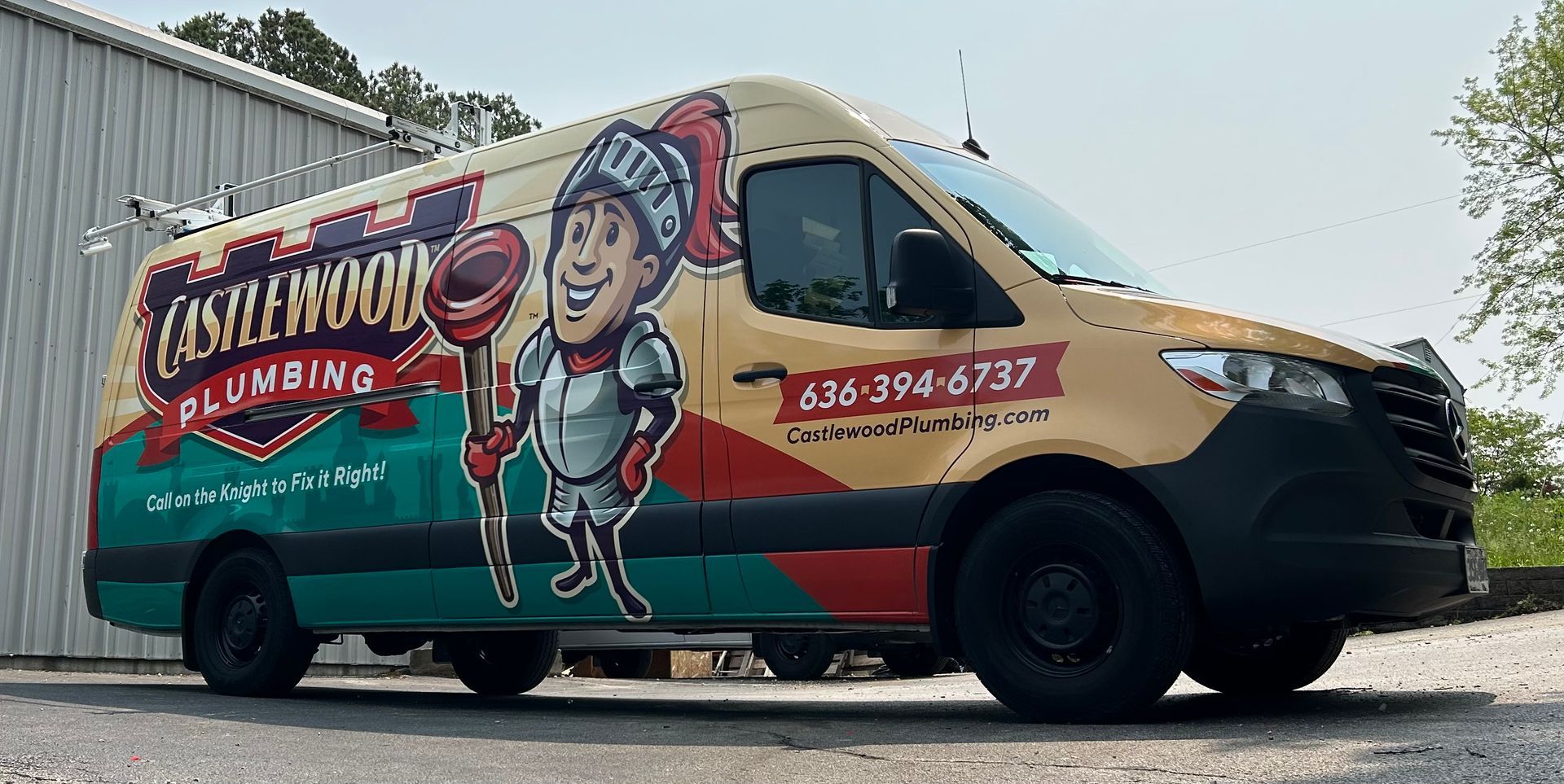 A plumbing service van with a knight holding a plunger. The van is light tan and teal.