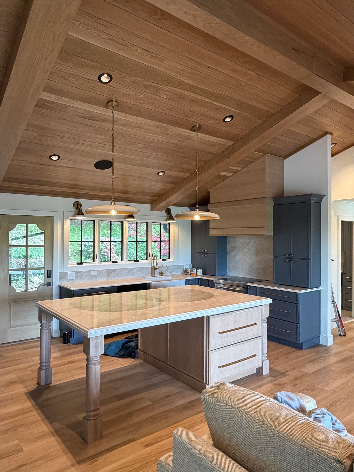 Modern kitchen with wood-paneled vaulted ceiling, large island, and pendant lights