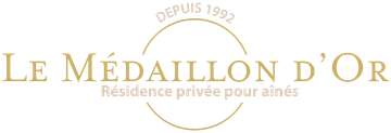 Logo doré du Médaillon d'Or, résidence privée pour seniors, fondée en 1992, sur fond blanc.