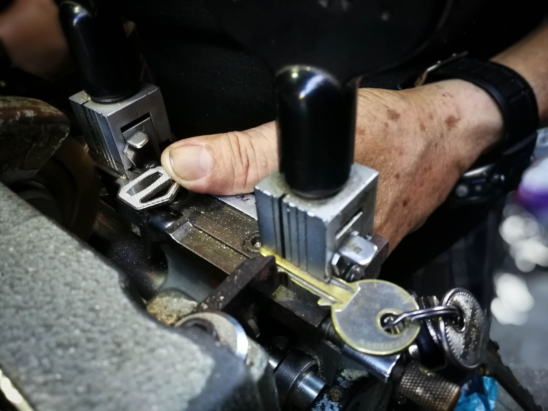 A locksmith using a key-cutting machine to duplicate a key.