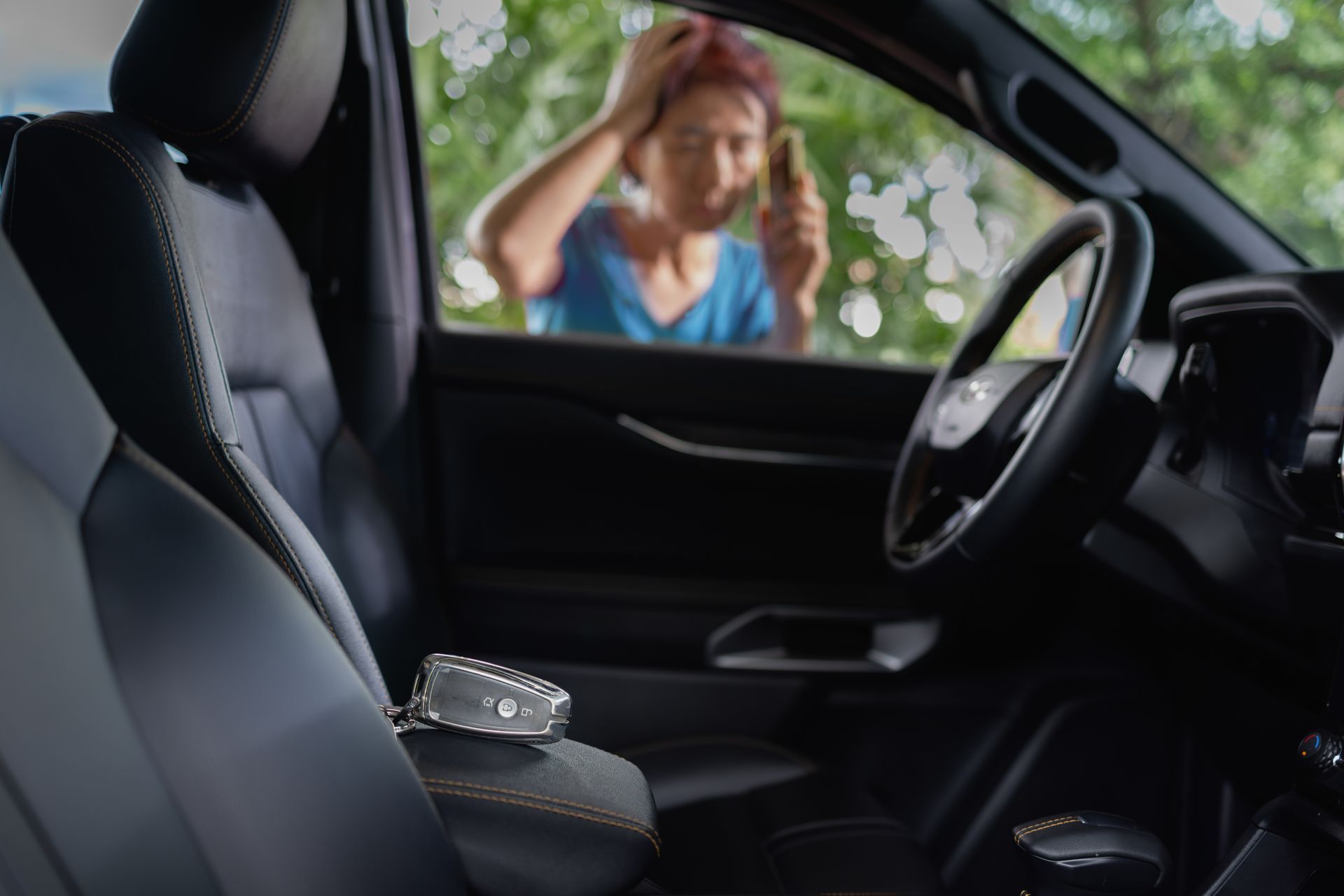Woman locked out of a car, keys on the center console, looking frustrated.