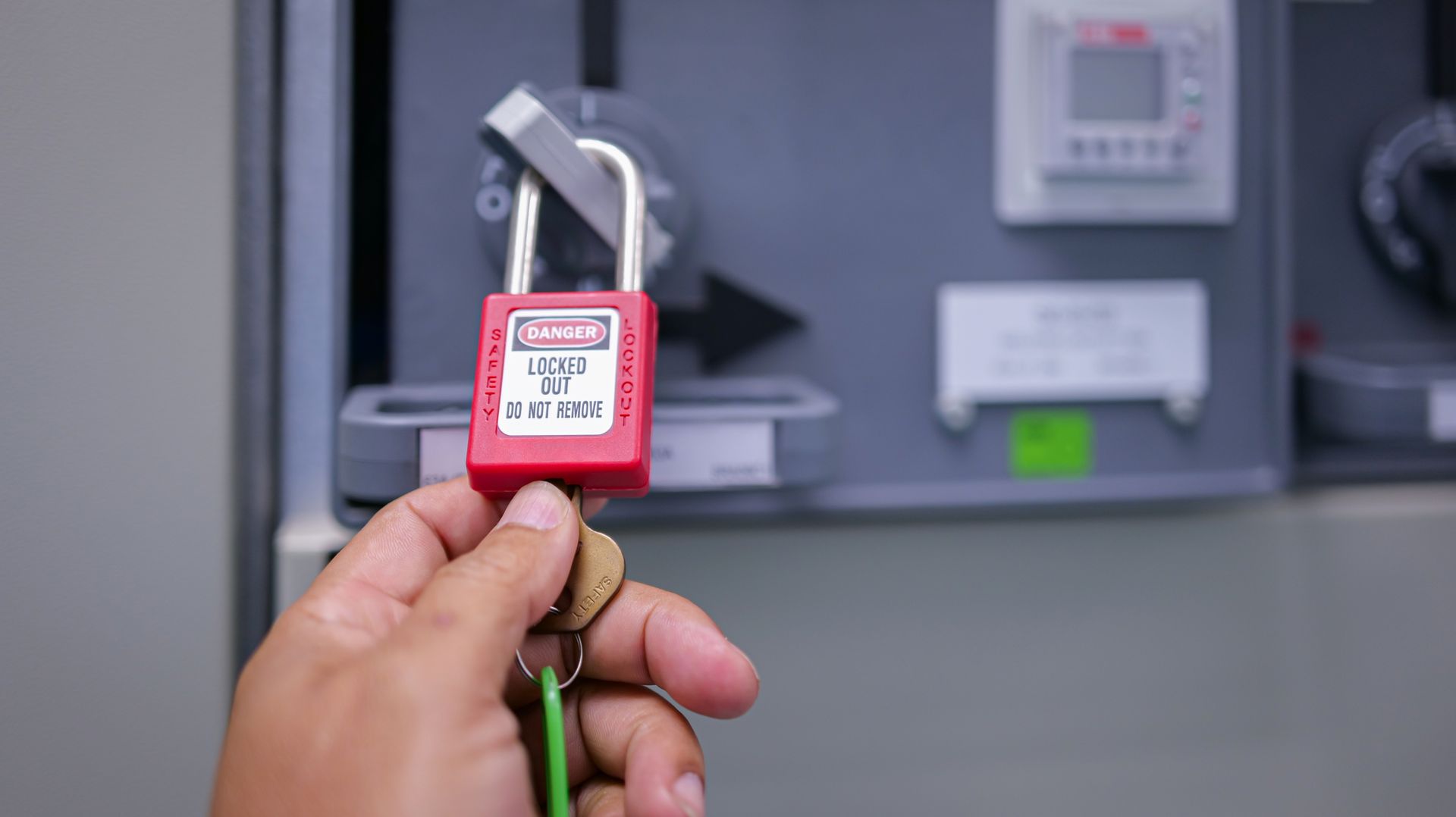 Hand holding a red padlock with a 