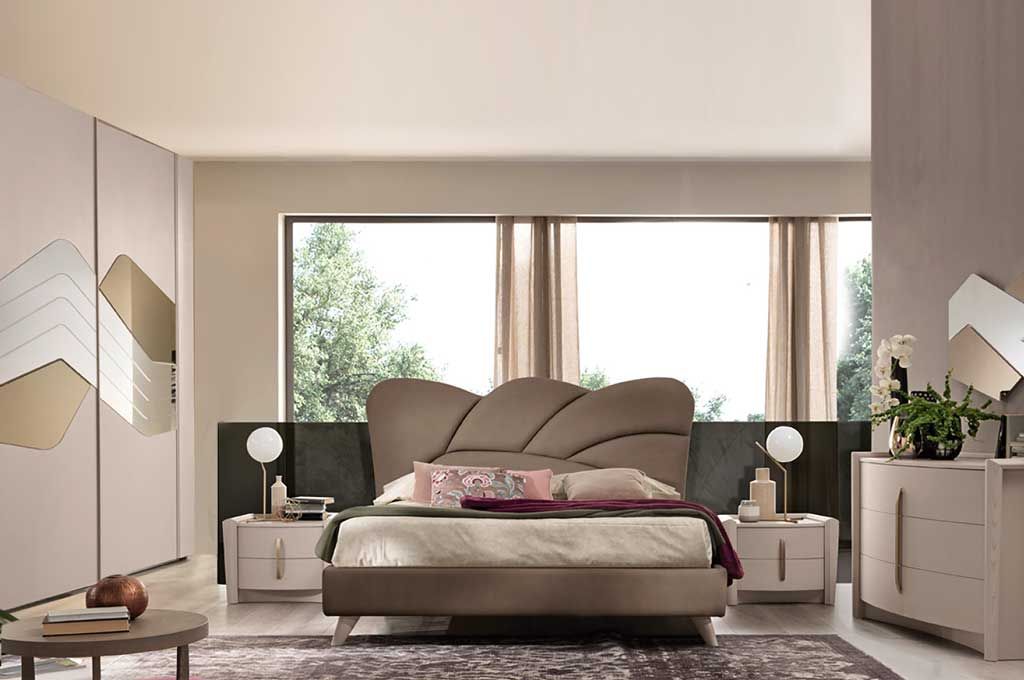 Camera da letto con letto, comodini, armadio e cassettiera in tonalità neutre.