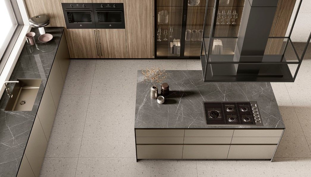 Cucina moderna con isola, piano cottura e cappa. Piani di lavoro e mobili grigi, parete in legno e dettagli in acciaio inossidabile.