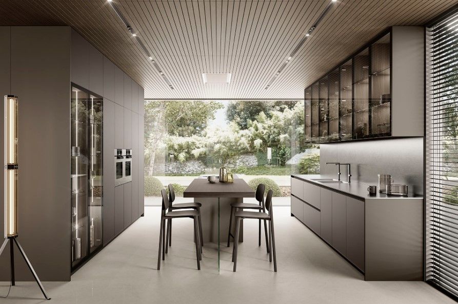 Cucina moderna con mobili grigi, isola e ampia finestra con vista sul verde.